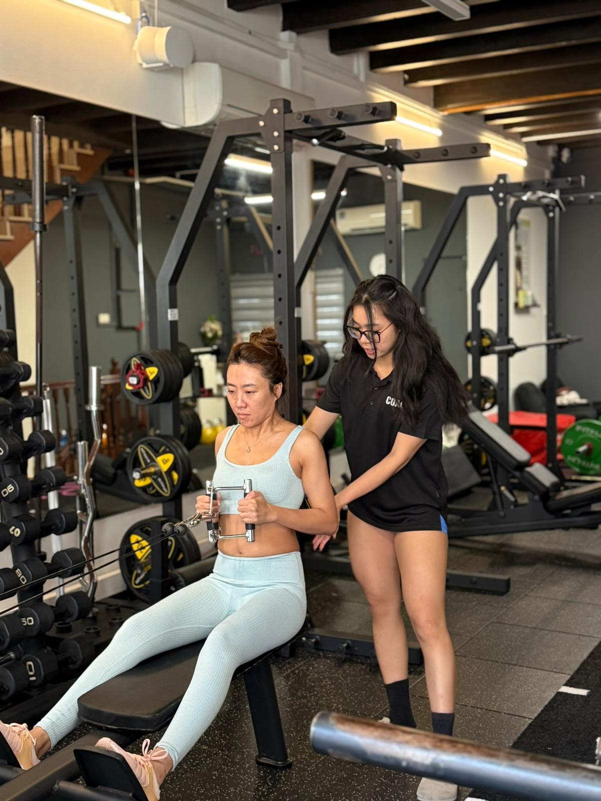 NNPT coach supporting a client during a seated cable row